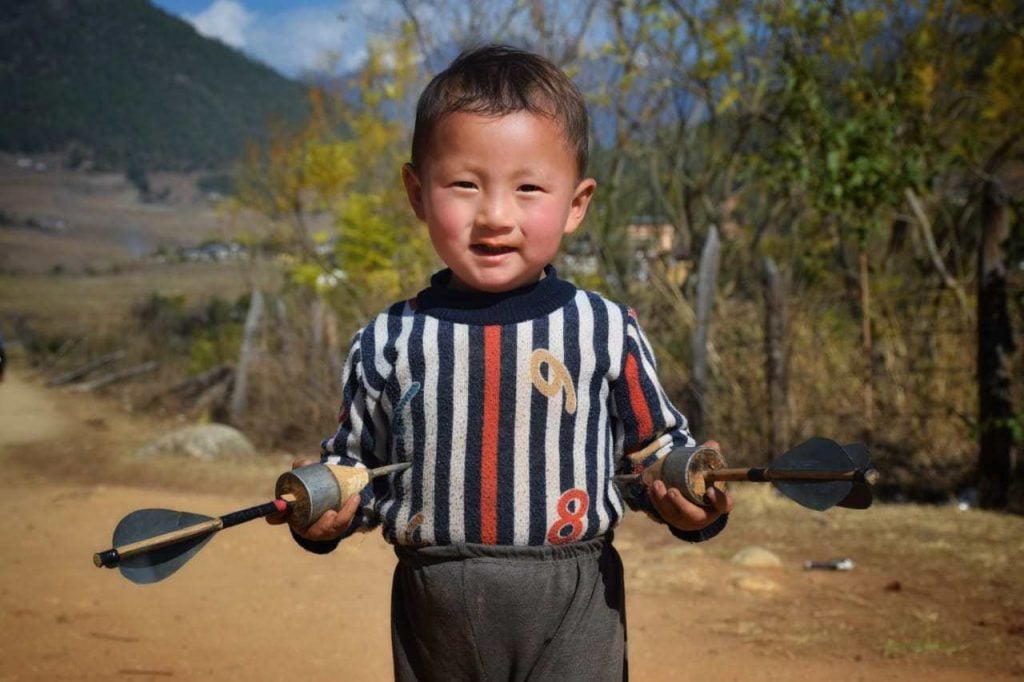 Bhutanese toddler playing Dart